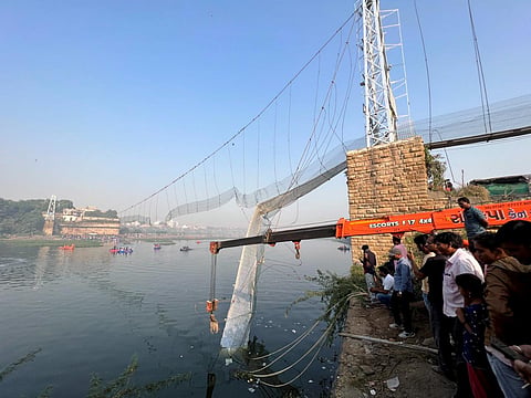 Rescue operation underway after the collapse of a suspension bridge over the Machchhu river, in Morbi district. (Photo | PTI)