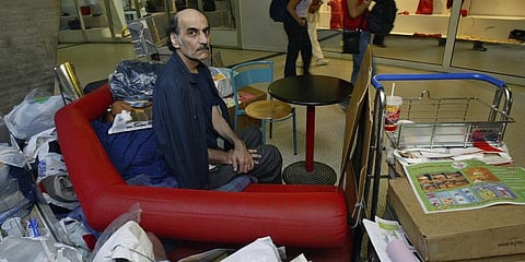 Merhan Karimi Nasseri sits among his belongings at Terminal 1 of Roissy Charles De Gaulle Airport, north of Paris on Aug. 11, 2004 . (Photo | AP)
