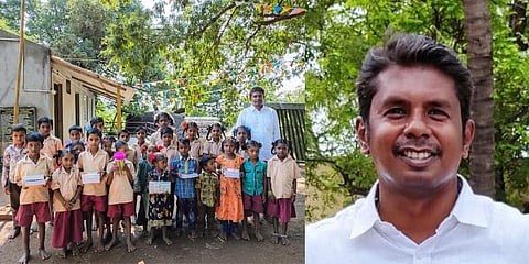 Giridharan with tribal kids in front of the school he helped build in Maruthavallimedu atop Alleri hills in Vellore. (Photo | Express)
