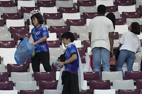 A Neat Act: Japanese fans clearing garbage from the seats. (Photo | AP)