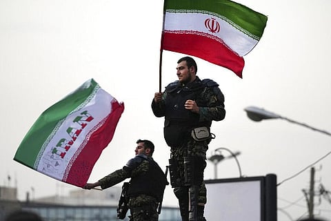 Two anti-riot police officers wave the Iranian flags during a street celebration after Iran defeated Wales in Qatar's World Cup, at Sadeghieh Sq. in Tehran, Iran, Friday, Nov. 25, 2022. (Photo | AP)