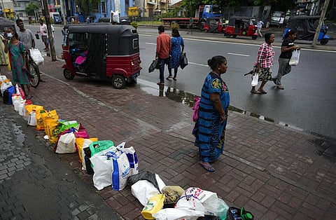 In this file image, people place their canisters in line as they wait to buy kerosene oil outside a fuel station in Colombo, Sri Lanka, June 11, 2022 (Photo | AP)