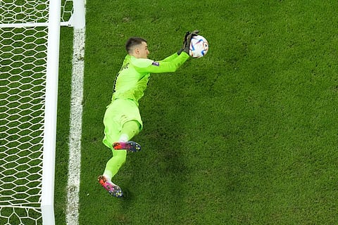 Dominik Livakovic saves a shot during a penalty shootout during the World Cup quarterfinal soccer match against Brazil, at the Education City Stadium, Qatar, Dec. 9, 2022. (Photo | AP)