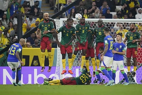 Cameroon's defensive wall jumps to block a free kick of Brazil's Dani Alves, left, during the World Cup group G soccer match against Brazil, at the Lusail Stadium, Qatar, Friday, Dec. 2, 2022. (Photo