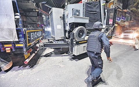 An NSG personnel escorts the Bomb Disposal Squad vehicle carrying the IED found in Old Seemapuri on Thursday, Feb 17, 2022. (Photo | PTI)