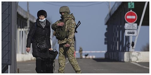 A woman crosses a checkpoint from the territory controlled by Russia-backed separatists to the territory controlled by Ukrainian forces in Novotroitske, eastern Ukraine on Monday. (Photo: AP)