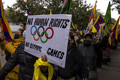 Exile Tibetans hold placards as they march towards Chinese embassy during a protest against Beijing Winter Olympic Games in New Delhi. (Photo | AP)