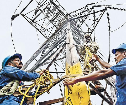File photo of Tangedco staff working on an electricity tower
