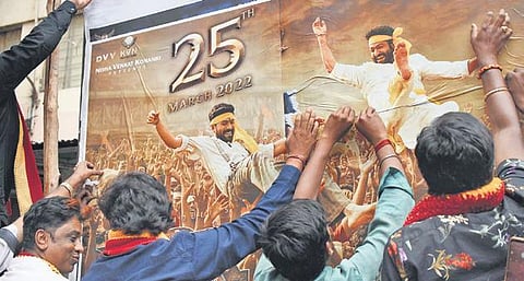 Members of Kannada organisations tear posters of the Telagu movie RRR at Anupama Theatre in Bengaluru on Thursday