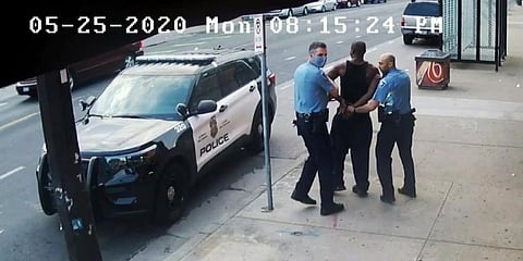 Minneapolis police Officers Thomas Lane (L) and J. Alexander Kueng (R) escorting George Floyd (C) to a police vehicle outside Cup Foods in Minneapolis. (File Photo | AP)