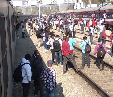 Scene at Tyakal railway station, 60 kms from Bengaluru, where passengers were trespassing on tracks after many trains came to a halt due to power failure. (Photo | EPS)