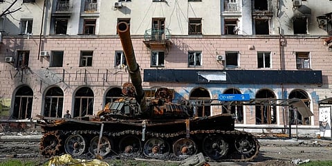 A destroyed tank and a damaged apartment building from heavy fighting are seen in Mariupol. (Photo | AP)
