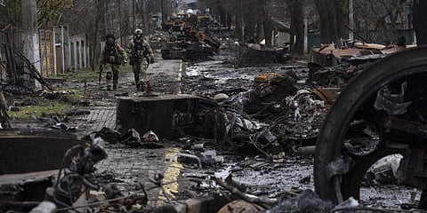 Soldiers walk amid destroyed Russian tanks in Bucha, on the outskirts of Kyiv, Ukraine. (Photo |AP)