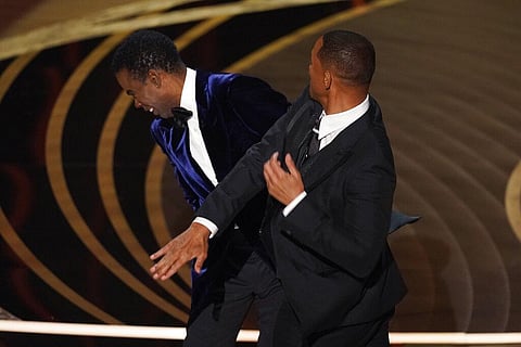 Will Smith, right, hits presenter Chris Rock on stage while presenting the award for best documentary feature at the Oscars. (Photo | AP)