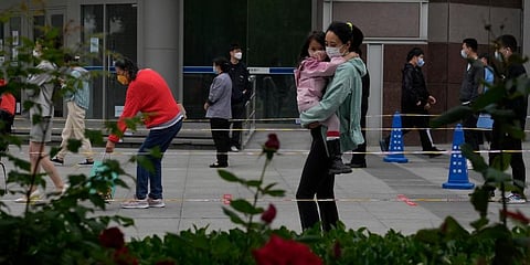 Residents wearing masks line up for mass Covid testing on Tuesday, May 10, 2022, in Beijing. (Photo | AP)