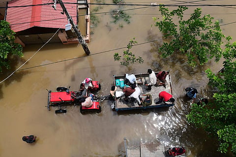 BBMP workers carrying food packets to distribute to residents of Vaddarapalya near Horamavu who were severely affected due to heavy rainfall. (Photo | Shriram BN, EPS)
