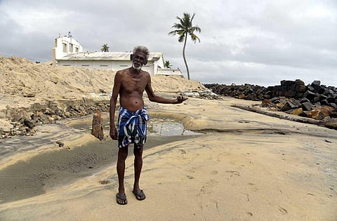 Kunjappan standing in front of seawall at Veliyathamparambu. (Photo | A Sanesh, EPS)