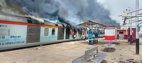 A train set on fire by youngsters in protest against the Centre's 'Agnipath' scheme at Lakhisarai Railway Station, in Lakhisarai. (Photo | PTI)