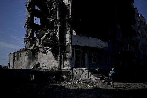 A woman walks past a building destroyed in Russian shelling in Borodyanka, on the outskirts of Kyiv, Ukraine, Tuesday, June 21, 2022. (Photo | AP)