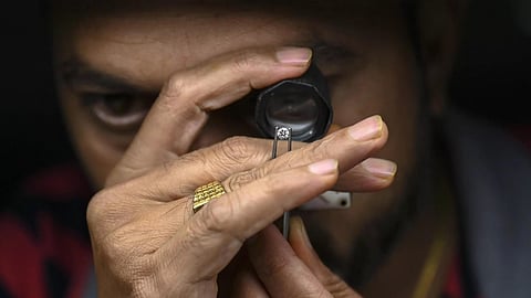 An artisan examining diamonds under a microscope.