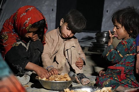 Afghan children eat in a makeshift shelter after an earthquake in Gayan district. (Photo | AP)