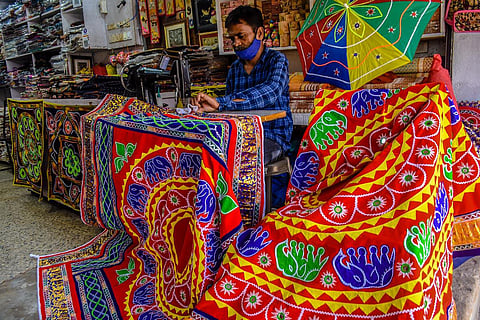 An artist busy sewing a Chandua to meet the Rath Yatra demand, in Pipili. (Photo | Express)