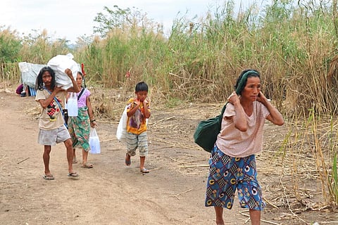 Displaced people from Myanmar carry donated lunch boxes to their tents along the Thai side of the Moei River in Mae Sot, Thailand on Feb. 5, 2022. (Photo | AP)