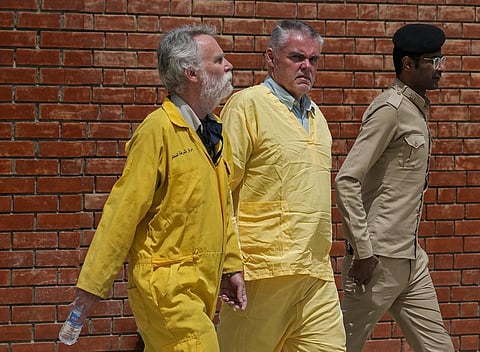 Jim Fitton of Britain(L) and Volker Waldman of Germany(C) are escorted by Iraqi security forces, outside a courtroom, in Baghdad. (Photo | AP)