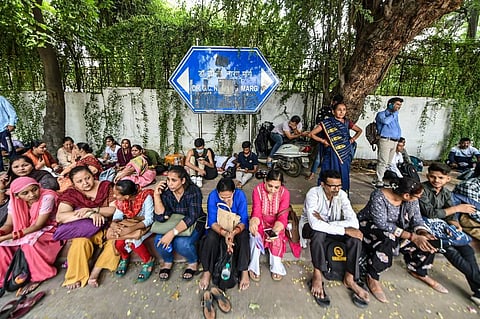 Family members wait at the Delhi University as students appear in the Common University Entrance Test (CUET) 2022, in New Delhi.