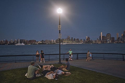 People spend time at the park at dusk during a summer heat wave in Hoboken. (Photo | AP)