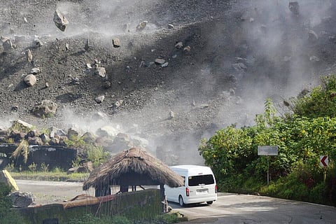Boulders fall as a vehicle negotiates a road during an earthquake in Bauko, Mountain Province, Philippines on July 27, 2022. (Photo | AP)