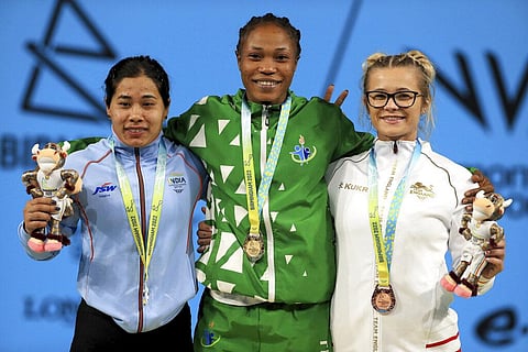 Gold medalist Nigeria's Adijat Adenike Olarinoye, center, silver medalist India's Bindyarani Devi Sorokhaibam, left, and bronze medalist England's Fraer Morrow. (Photo | AP)