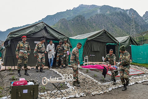Army soldiers carry an injured pilgrim who was evacuated from the flash flood area near the Amarnath cave shrine by helicopter, at Baltal base camp in Ganderbal district of Central Kashmir, on July 9,