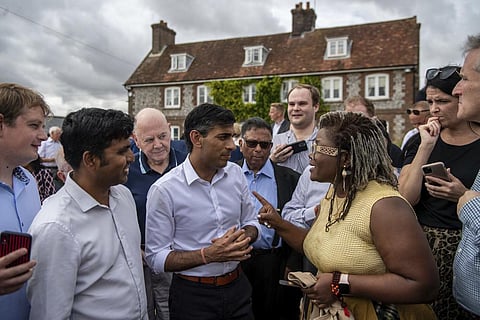 Britain's former Chancellor of the Exchequer Rishi Sunak, centre, speaks to people at an event in England. (Photo | AP)