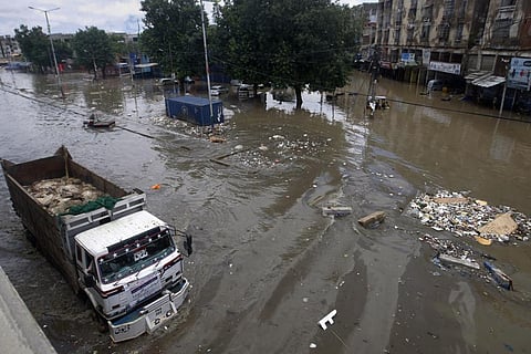 In this file picture, a truck drives through a flooded road after a heavy rainfall in Karachi, Pakistan on July 11, 2022. (Photo | AP)