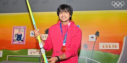 Track & field athlete Neeraj Chopra poses with his javelin that won him the gold medal at the Summer Olympics 2020, at The Olympic Museum in Lausanne. (Photo | PTI)