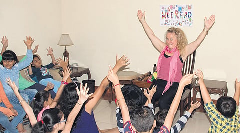 Anna Jarrett (on chair, in pink) conducts a storytelling workshop for the children who are a part of ‘Wee Read