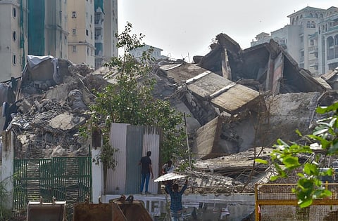 Labourers put up metal sheets to barricade the mound of debris of the demolished twin towers of Supertech, in Noida, Tuesday, Aug. 30, 2022. (Photo | PTI)