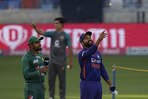 Pakistan's captain Babar Azam (left) watches as India's captain Rohit Sharma spins the coin at T20 cricket match of Asia Cup between India and Pakistan, in Dubai on Sunday. (Photo | PTI)