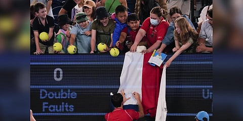 Daniil Medvedev of Russia autographs a Russian flag at the Australian Open Monday, Jan. 16, 2023.(Photo | AP)
