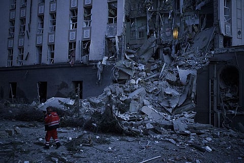 An emergency worker walks in front of a damaged hotel following a Russian attack in Kyiv, Ukraine, Saturday, Dec. 31, 2022. (Photo | AP)