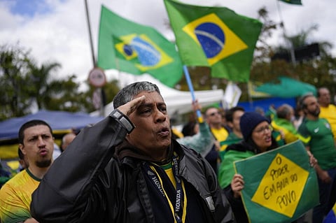 A Bolsonaro supporter salutes while singing the nation's anthem outside a military base during a protest against his reelection defeat in Sao Paulo, Nov. 3, 2022. (File Photo | AP)