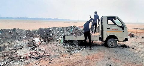 Garbage being dumped from a small goods carrier on Kathajodi riverbed in Cuttack | Express