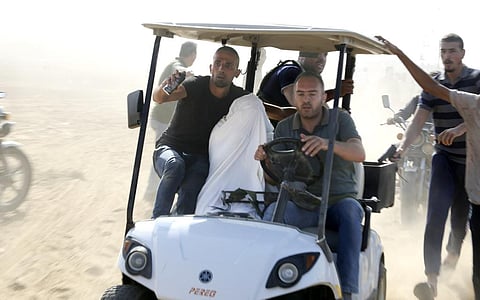 Palestinians transport a captured Israeli civilian from Kibbutz Kfar Azza into the Gaza Strip on Saturday, Oct. 7, 2023. (Photo | AP)