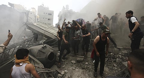 Palestinians remove a dead body from the rubble of a building after an Israeli airstrike on the Jebaliya refugee camp, Gaza Strip. (Photo | AP)
