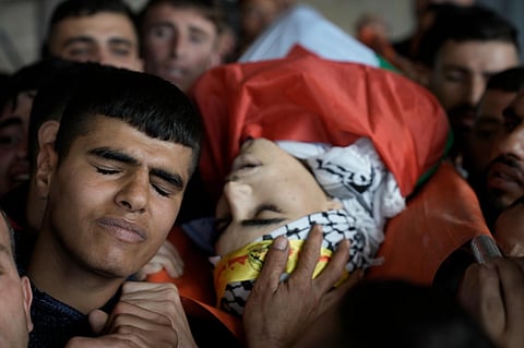 Palestinian mourners carry the body of Akram Dweikat, 17, killed in clashes with Israeli forces during his funeral in the West Bank city of Nablus, Sunday, October 15, 2023. (Photo | AP)