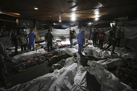 Bodies of Palestinians killed by an explosion at the Ahli Arab hospital are gathered in the front yard of the al-Shifa hospital. (Photo | AP)