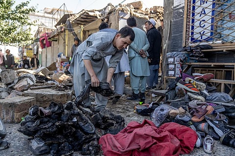 An Afghan man removes the burnt shoes in the site of an explosion in a sports club, in the west of Kabul, Afghanistan, Friday, Oct. 27, 2023. (Photo | AP)