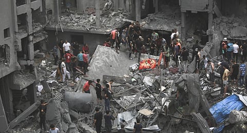 Palestinians inspect the damage of destroyed buildings following Israeli airstrikes on Gaza City.