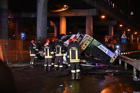 Firefighters work on the site of a bus accident on October 03, 2023 in Mestre, near Venice. The bus caught fire after careering off a bridge linking the Mestre and Marghera districts. (Photo | AFP)